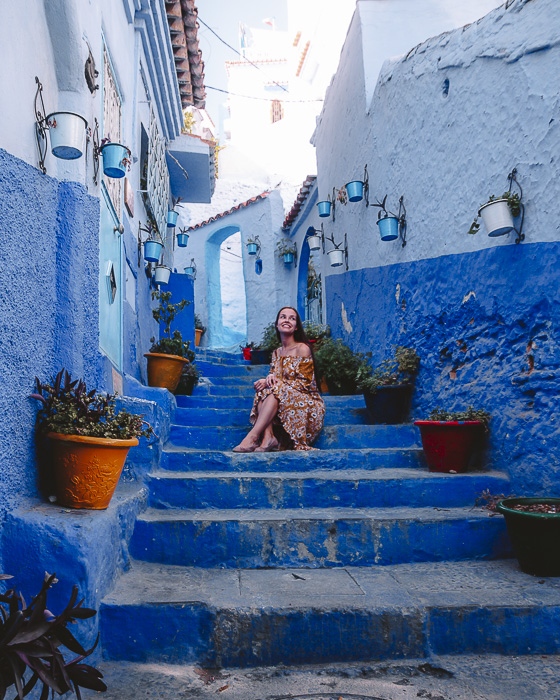 Morocco travel guide Chefchaouen sitting on ocean-blue staircases by Dancing the Earth