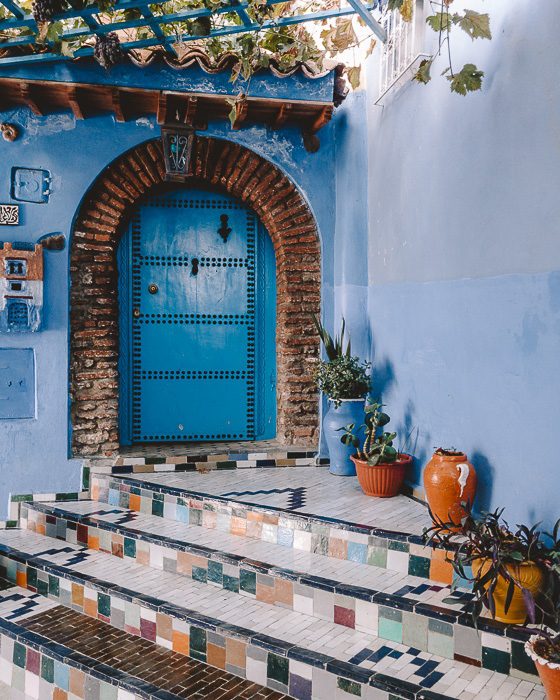 Small door and tiled stairs in Chefchaouen by Dancing the Earth